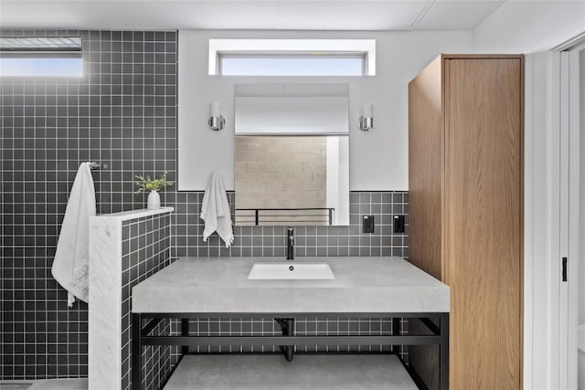 700 Denson Dr Unit 2101, Austin, TX 78752 - bathroom with a sink, tile walls, backsplash, and plenty of natural light