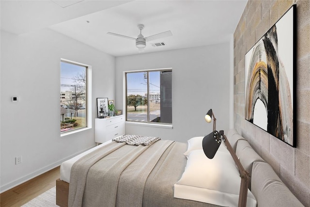 700 Denson Dr Unit 2101, Austin, TX 78752 - bedroom with wood finished floors, baseboards, and a ceiling fan