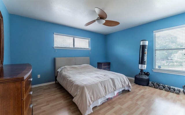 2104 New York Ave, Austin, TX 78702 - bedroom featuring light wood finished floors, multiple windows, ceiling fan, and baseboards