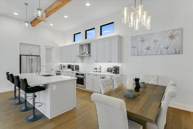 13322 Galleria Cir, Austin, TX 78738 - dining area featuring a high ceiling, a chandelier, beam ceiling, light wood-style flooring, and recessed lighting