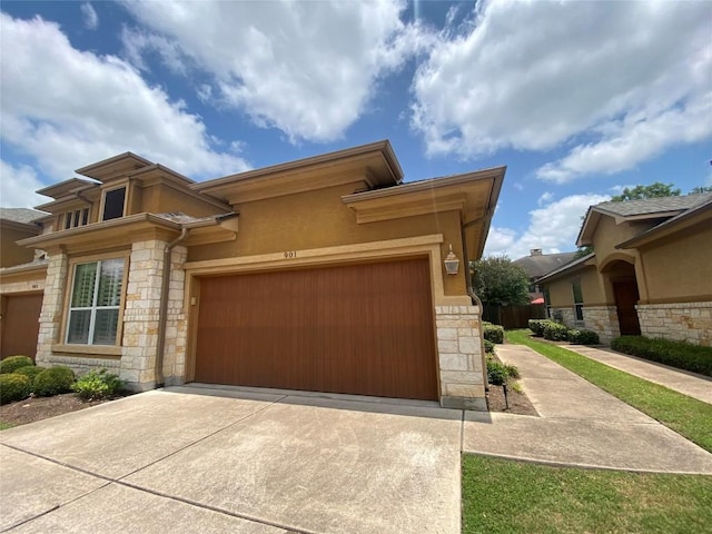 2210 Onion Creek Pkwy Unit 901, Austin, TX 78747 - prairie-style home featuring stone siding, concrete driveway, a garage, and stucco siding