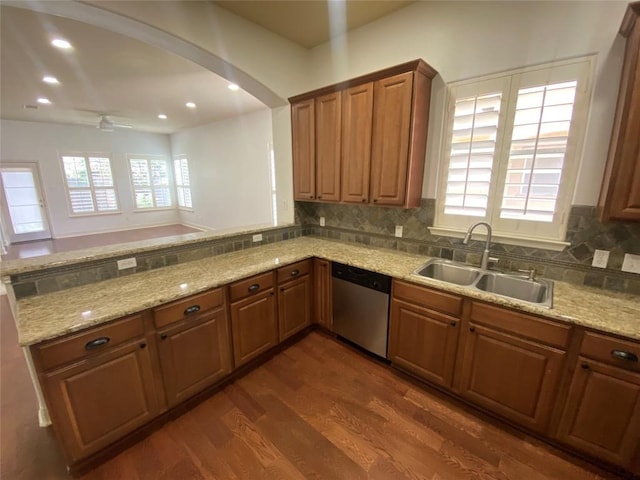 2210 Onion Creek Pkwy Unit 901, Austin, TX 78747 - kitchen featuring dishwasher, a sink, dark wood finished floors, light stone countertops, and brown cabinetry