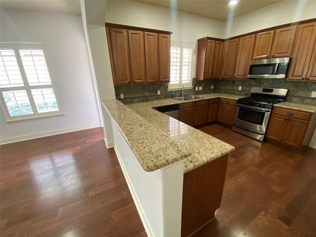 2210 Onion Creek Pkwy Unit 901, Austin, TX 78747 - kitchen with stainless steel appliances, a sink, a peninsula, and decorative backsplash