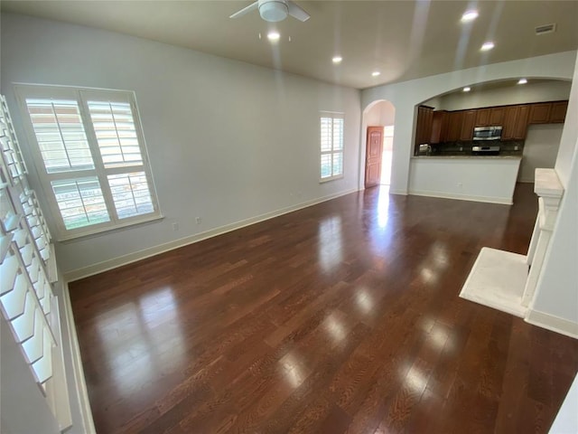 2210 Onion Creek Pkwy Unit 901, Austin, TX 78747 - unfurnished living room featuring arched walkways, a ceiling fan, recessed lighting, dark wood-style flooring, and baseboards