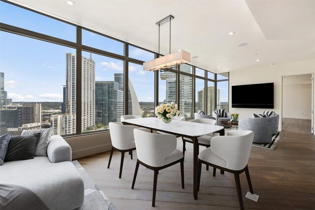 501 W Ave Unit 2303, Austin, TX 78701 - dining room featuring wood finished floors, a city view, baseboards, and recessed lighting