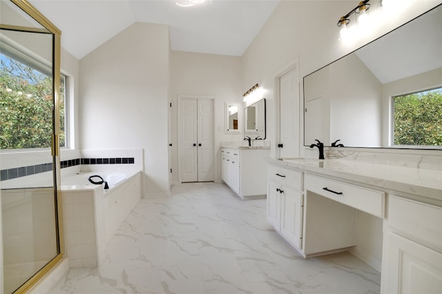 6601 Needham Ln, Austin, TX 78739 - bathroom with vaulted ceiling, marble look tiles, two vanities, a garden tub, and a stall shower
