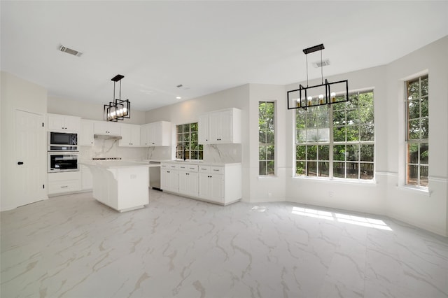 6601 Needham Ln, Austin, TX 78739 - kitchen with white oven, black microwave, a chandelier, stainless steel dishwasher, and plenty of natural light