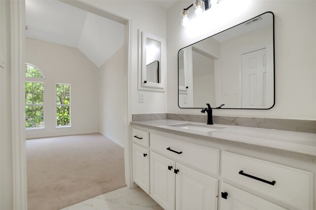 6601 Needham Ln, Austin, TX 78739 - bathroom with vanity, marble look tiles, and vaulted ceiling