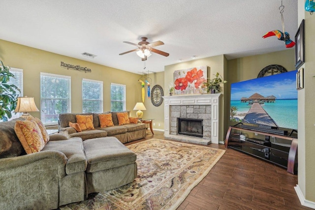3502 Blackstone Run, San Antonio, TX 78259 - living area with a ceiling fan, wood finished floors, a stone fireplace, a textured ceiling, and baseboards