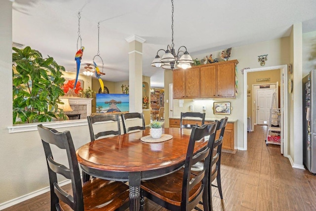 3502 Blackstone Run, San Antonio, TX 78259 - dining area with a chandelier, baseboards, wood finished floors, and a fireplace