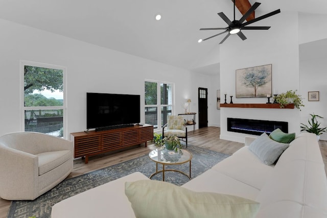 1174 Desiree St, Canyon Lake, TX 78133 - living area featuring ceiling fan, wood finished floors, high vaulted ceiling, a glass covered fireplace, and recessed lighting