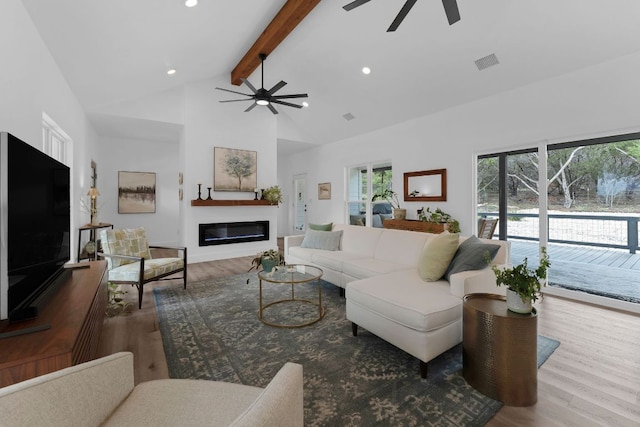 1174 Desiree St, Canyon Lake, TX 78133 - living room featuring a ceiling fan, beamed ceiling, high vaulted ceiling, a glass covered fireplace, and wood finished floors