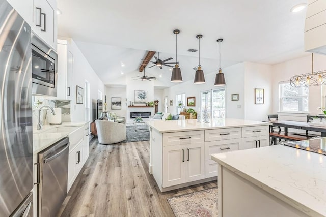 1174 Desiree St, Canyon Lake, TX 78133 - kitchen featuring stainless steel appliances, light wood-style flooring, a ceiling fan, white cabinetry, and healthy amount of natural light