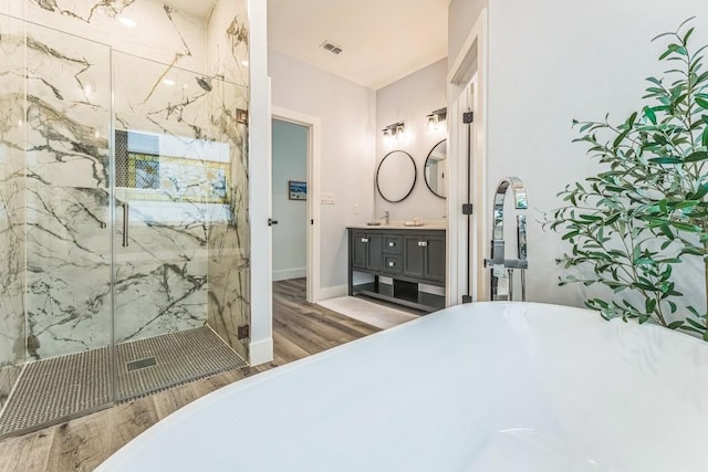 1174 Desiree St, Canyon Lake, TX 78133 - full bathroom with wood finished floors, a freestanding tub, vanity, and a marble finish shower
