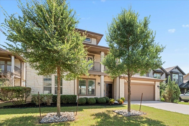 9305 Mcknight Loop Unit 4, Austin, TX 78717 - obstructed view of property featuring a balcony, concrete driveway, stone siding, a front yard, and an attached garage