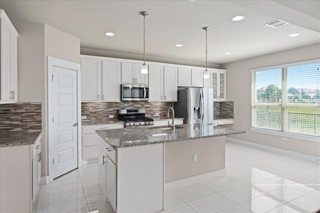 9305 Mcknight Loop Unit 4, Austin, TX 78717 - kitchen featuring stainless steel appliances, tasteful backsplash, a kitchen island with sink, light tile patterned floors, and recessed lighting