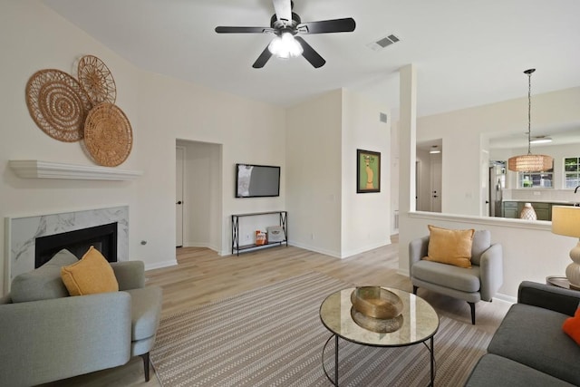 21017 Secretariat Ridge Ln, Pflugerville, TX 78660 - living area with light wood-style floors, ceiling fan, a fireplace, and baseboards