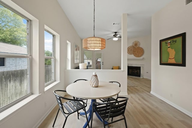 21017 Secretariat Ridge Ln, Pflugerville, TX 78660 - dining room with ceiling fan, a high end fireplace, light wood-style flooring, and baseboards