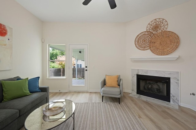 21017 Secretariat Ridge Ln, Pflugerville, TX 78660 - living room featuring wood finished floors, a ceiling fan, a high end fireplace, and baseboards