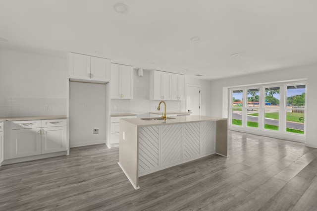 2101 Vanderbilt Ln, Austin, TX 78723 - kitchen featuring light wood-style flooring, tasteful backsplash, and white cabinets