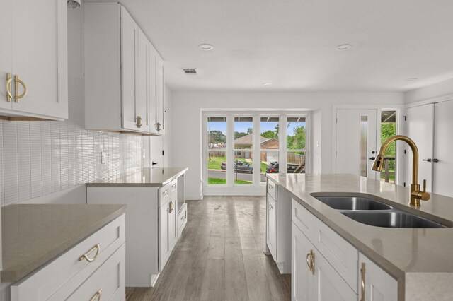 2101 Vanderbilt Ln, Austin, TX 78723 - kitchen with healthy amount of natural light, recessed lighting, white cabinets, backsplash, and light wood finished floors
