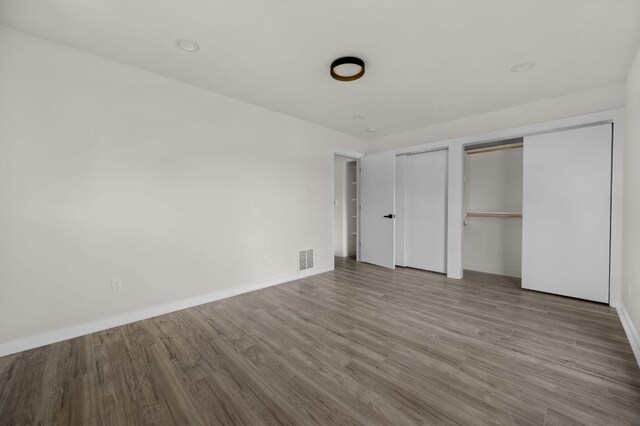 2101 Vanderbilt Ln, Austin, TX 78723 - unfurnished bedroom featuring two closets and wood finished floors