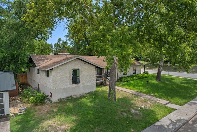 2101 Vanderbilt Ln, Austin, TX 78723 - view of front of home with a shingled roof, a front yard, and stone siding