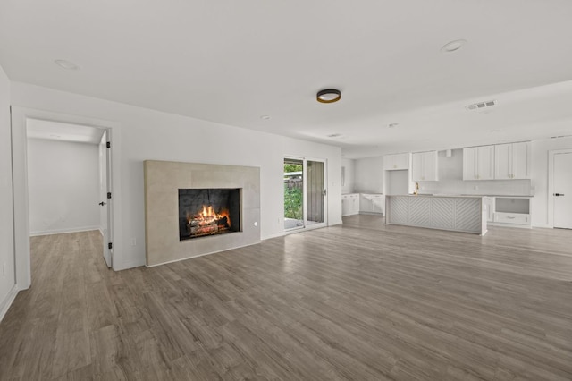 2101 Vanderbilt Ln, Austin, TX 78723 - unfurnished living room featuring wood finished floors and a tile fireplace