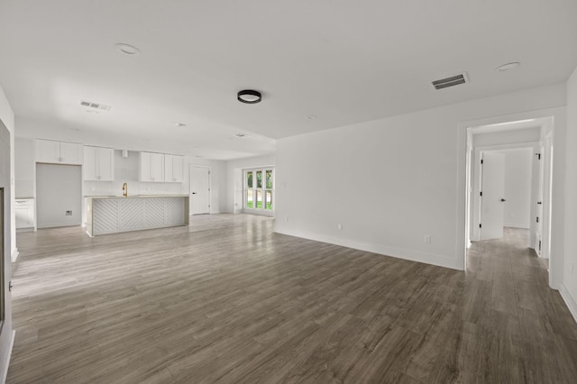 2101 Vanderbilt Ln, Austin, TX 78723 - unfurnished living room featuring wood finished floors and a sink