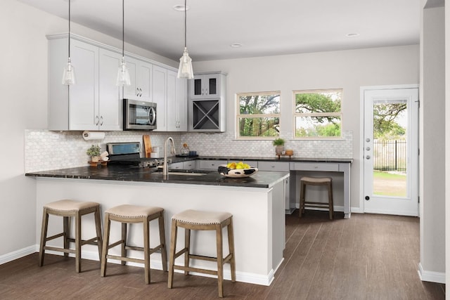 299 Diamond Point Dr, Dripping Springs, TX 78620 - kitchen featuring stainless steel microwave, range with electric cooktop, a peninsula, dark countertops, and recessed lighting