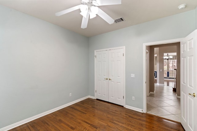 9501 Aire Libre Dr, Austin, TX 78726 - unfurnished bedroom featuring a chandelier, wood finished floors, baseboards, a closet, and a ceiling fan