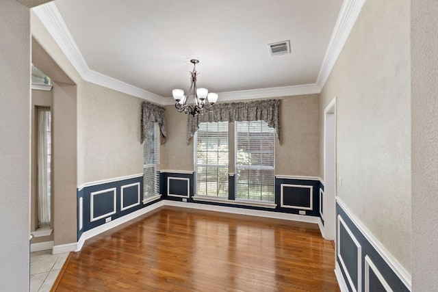 9501 Aire Libre Dr, Austin, TX 78726 - unfurnished dining area featuring crown molding, a chandelier, wood finished floors, and wainscoting