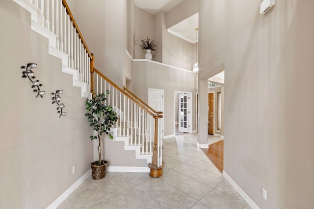 9501 Aire Libre Dr, Austin, TX 78726 - foyer featuring tile patterned flooring, a high ceiling, stairs, and baseboards