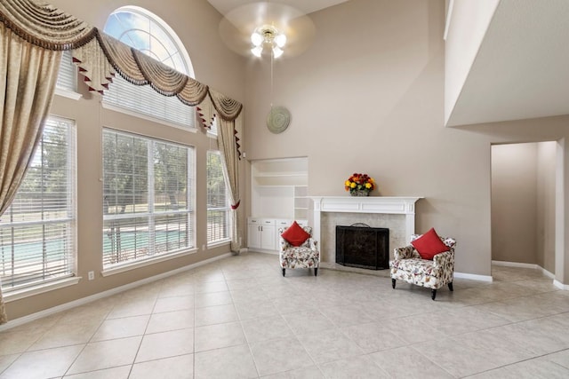 9501 Aire Libre Dr, Austin, TX 78726 - sitting room with a fireplace, light tile patterned floors, a high ceiling, ceiling fan, and baseboards