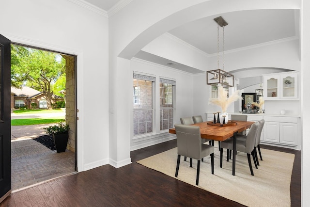 10833 Olympia Fields Loop, Austin, TX 78747 - dining space featuring arched walkways, wood finished floors, crown molding, a chandelier, and baseboards