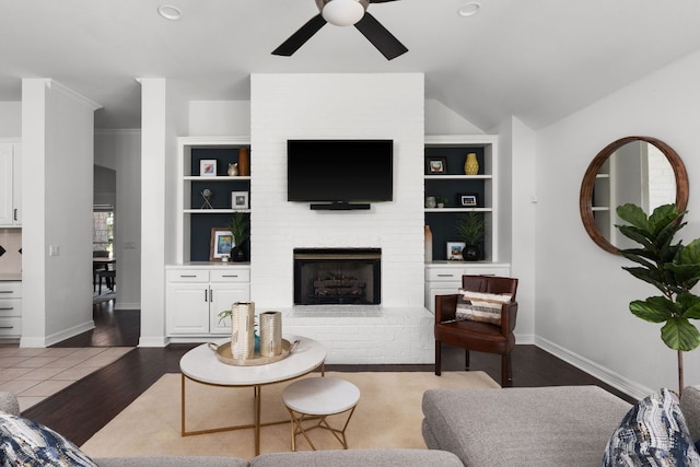 10833 Olympia Fields Loop, Austin, TX 78747 - living room with ceiling fan, built in shelves, a brick fireplace, baseboards, and lofted ceiling