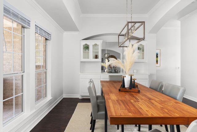 10833 Olympia Fields Loop, Austin, TX 78747 - dining room featuring dark wood-type flooring, ornamental molding, arched walkways, and baseboards