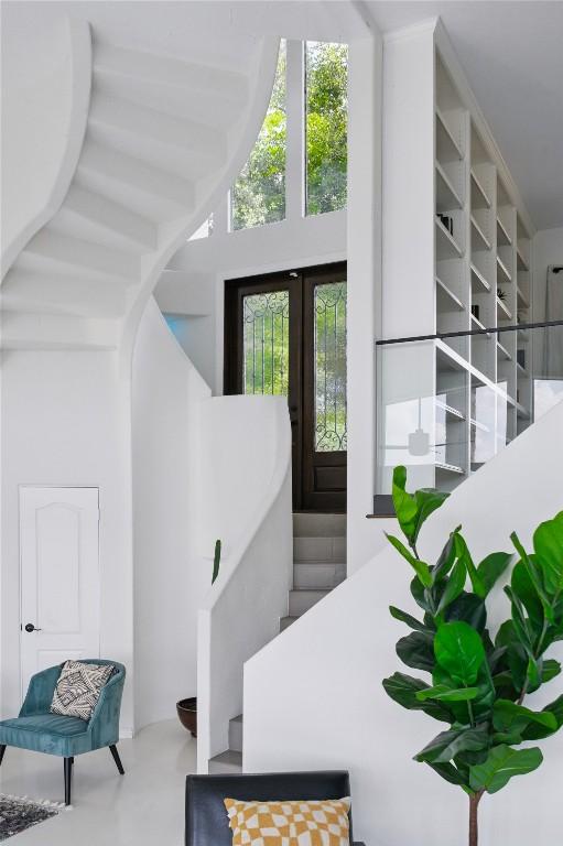 13902 Panorama Dr, Austin, TX 78732 - stairs featuring a high ceiling, arched walkways, and french doors