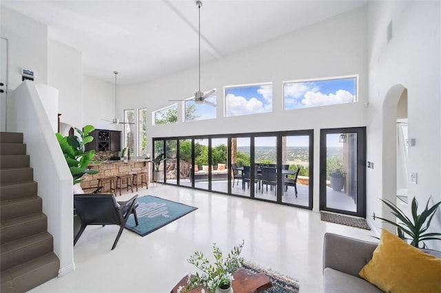 13902 Panorama Dr, Austin, TX 78732 - living area with ceiling fan, a high ceiling, healthy amount of natural light, arched walkways, and stairway