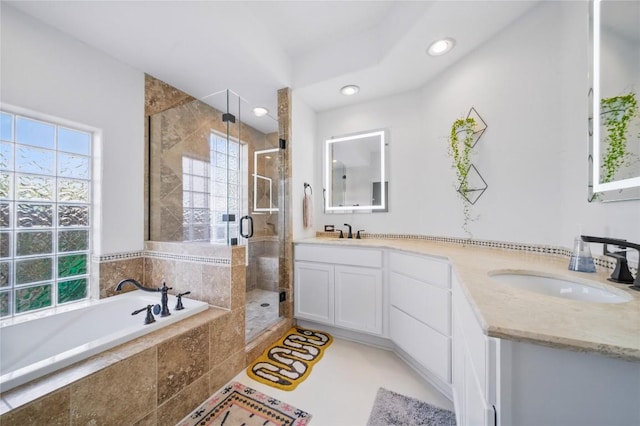 13902 Panorama Dr, Austin, TX 78732 - full bathroom featuring double vanity, healthy amount of natural light, a bath, a stall shower, and recessed lighting
