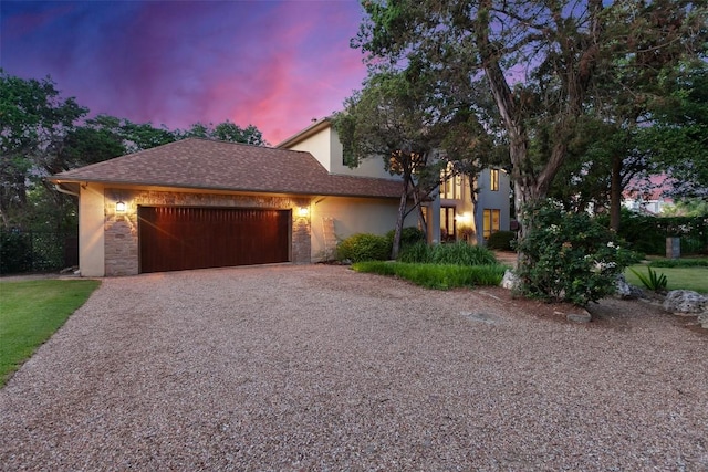 13902 Panorama Dr, Austin, TX 78732 - view of front facade with an attached garage, gravel driveway, stucco siding, and stone siding