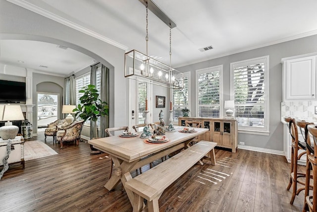 404 Riley Trl, Cedar Park, TX 78613 - dining area with arched walkways, dark wood-type flooring, a chandelier, ornamental molding, and baseboards