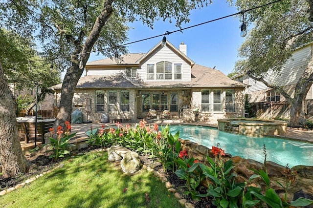 404 Riley Trl, Cedar Park, TX 78613 - back of property featuring a chimney, a pool with connected hot tub, and a patio