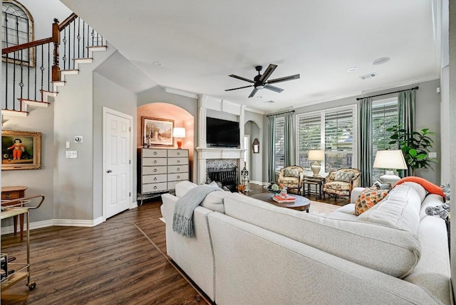 404 Riley Trl, Cedar Park, TX 78613 - living room featuring baseboards, dark wood-style floors, arched walkways, a fireplace, and a ceiling fan