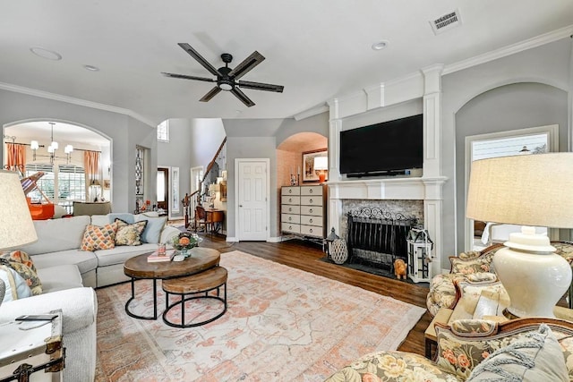 404 Riley Trl, Cedar Park, TX 78613 - living area featuring ceiling fan, wood finished floors, ornamental molding, a fireplace with flush hearth, and arched walkways