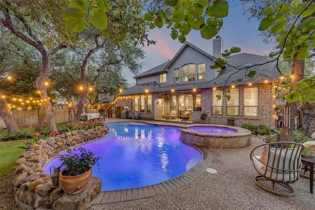 404 Riley Trl, Cedar Park, TX 78613 - pool at dusk with a fenced backyard, a patio area, and a pool with connected hot tub