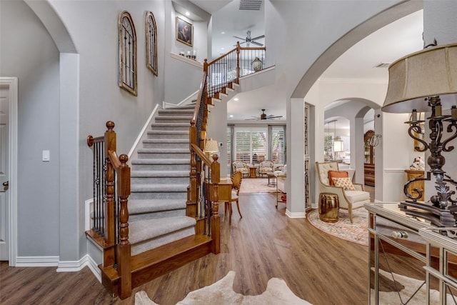404 Riley Trl, Cedar Park, TX 78613 - entrance foyer featuring a ceiling fan, wood finished floors, stairway, crown molding, and arched walkways