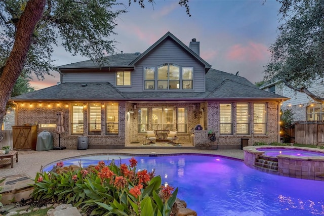 404 Riley Trl, Cedar Park, TX 78613 - back of house featuring a patio, brick siding, a chimney, and a pool with connected hot tub