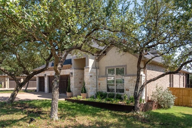 1225 Grassy Field Rd, Austin, TX 78737 - view of property hidden behind natural elements featuring stone siding, concrete driveway, stucco siding, and an attached garage