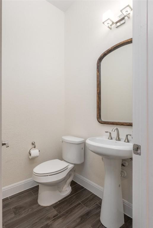 1225 Grassy Field Rd, Austin, TX 78737 - half bath with baseboards, toilet, wood finished floors, and a sink
